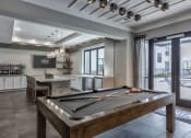 Thumbnail 5 of 25 - a pool table in a clubhouse with a kitchen and a bar