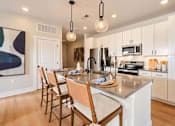 Thumbnail 1 of 29 - A kitchen with a table set for four with a painting on the wall.