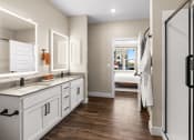 Thumbnail 82 of 94 - a bathroom with white cabinets and a shower and a sink