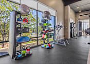 Thumbnail 8 of 34 - A gym with a variety of equipment including weights and a bench.