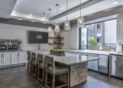 Thumbnail 3 of 25 - a kitchen with a large island with chairs and a counter top