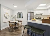Thumbnail 3 of 28 - A kitchen with a dining table and chairs.