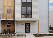 Thumbnail 41 of 45 - A modern house with a balcony and a garage door.