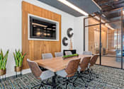 Thumbnail 6 of 34 - A conference room with a wooden table and chairs.