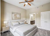 Thumbnail 17 of 39 - Pet-Friendly Luxury Apartments in Atlanta, GA - The Rocca - A Bedroom with Matching Bedside Tables with Lamps, a large bed, and a Ceiling Fan.