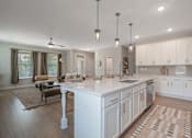 Thumbnail 5 of 65 - A modern kitchen with a large island and a dining area.