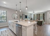 Thumbnail 6 of 65 - A modern kitchen with a large island and pendant lights.