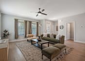 Thumbnail 10 of 65 - A living room with a brown rug and a green couch.