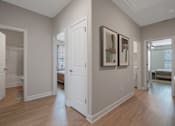 Thumbnail 11 of 65 - A room with a white door and a painting on the wall.