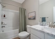 Thumbnail 27 of 65 - A white bathroom with a toilet, sink, and shower.