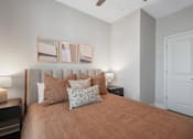 Thumbnail 25 of 65 - A bedroom with a bed, nightstands, and a ceiling fan.
