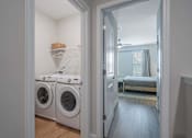 Thumbnail 12 of 65 - A laundry room with a washer and dryer in it.