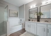 Thumbnail 21 of 65 - A bathroom with a white tub, sink, and mirror.