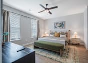 Thumbnail 16 of 65 - A bedroom with a bed, nightstands, and a ceiling fan.