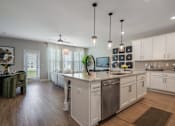 Thumbnail 33 of 65 - A kitchen with white cabinets and a wooden floor.