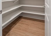 Thumbnail 32 of 65 - Empty white shelves in a room with a wooden floor.