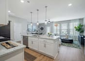 Thumbnail 34 of 65 - A modern kitchen with a granite countertop and white cabinets.