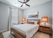 Thumbnail 47 of 65 - A bedroom with a bed, nightstands, and a ceiling fan.