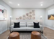 Thumbnail 40 of 65 - A living room with a white couch and a painting on the wall.
