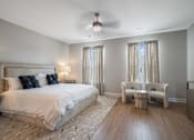 Thumbnail 42 of 65 - A bedroom with a large bed and a ceiling fan.