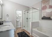 Thumbnail 44 of 65 - A bathroom with a marble countertop and a glass shower stall.
