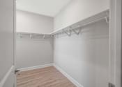 Thumbnail 46 of 65 - A white closet with a wooden floor and white walls.