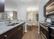 Thumbnail 3 of 38 - A kitchen with granite countertops and stainless steel appliances.