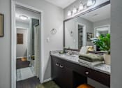 Thumbnail 11 of 38 - A bathroom with a vanity, mirror, and lights.