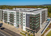 Thumbnail 34 of 34 - A large hotel named Arcadia with a parking lot in front.