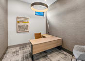 Thumbnail 33 of 94 - a desk in a room with a chair and a lamp