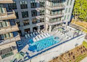 Thumbnail 33 of 34 - A large building with a pool in front of it.