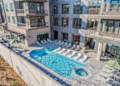 Thumbnail 14 of 34 - A large swimming pool surrounded by sun loungers and umbrellas.