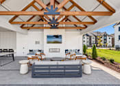 Thumbnail 21 of 29 - A patio with a grey couch and a wooden ceiling.