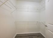 Thumbnail 20 of 35 - A white closet with a door and a grey floor.