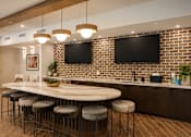 Thumbnail 13 of 40 - A kitchen with a bar area and a brick wall.