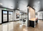 Thumbnail 10 of 94 - A modern office lobby with a reception desk and chairs.