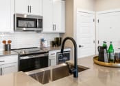 Thumbnail 68 of 94 - a kitchen with stainless steel appliances and white cabinets