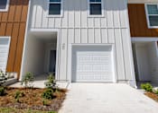 Thumbnail 66 of 71 - a house with a white garage door and brown and orange siding