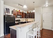 Thumbnail 3 of 42 - A kitchen with a black fridge and white cabinets.