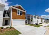 Thumbnail 67 of 71 - a row of townhomes with white and brown siding