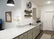 Thumbnail 23 of 31 - A kitchen with a white countertop and cabinets.