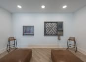Thumbnail 6 of 28 - a living room with two stools and two pieces of art on the wall