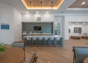 Thumbnail 4 of 28 - a communal area with a bar and chairs in a room with a table and chairs