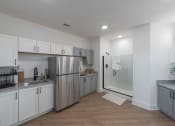 Thumbnail 16 of 28 - a kitchen with white cabinets and a stainless steel refrigerator
