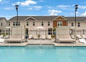 Thumbnail 49 of 71 - a swimming pool with chairs and umbrellas in front of a building