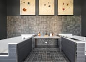 Thumbnail 48 of 71 - a bathroom with two tubs and paintings on the wall