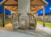 Thumbnail 63 of 71 - two rattan hanging chairs in front of a stone fireplace