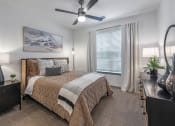 Thumbnail 17 of 21 - a bedroom with a bed and a ceiling fan