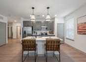 Thumbnail 3 of 21 - an open kitchen with a large island with two chairs in front of it