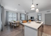 Thumbnail 7 of 21 - an open kitchen and living room with a dining room table and chairs and an island